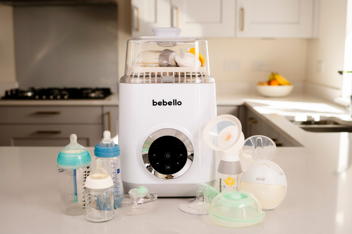 Bebello Washer on kitchen counter surrounded by various branded baby bottles and breast pumps